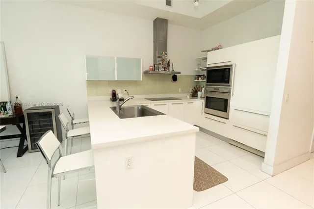 a kitchen with a sink appliances and cabinets