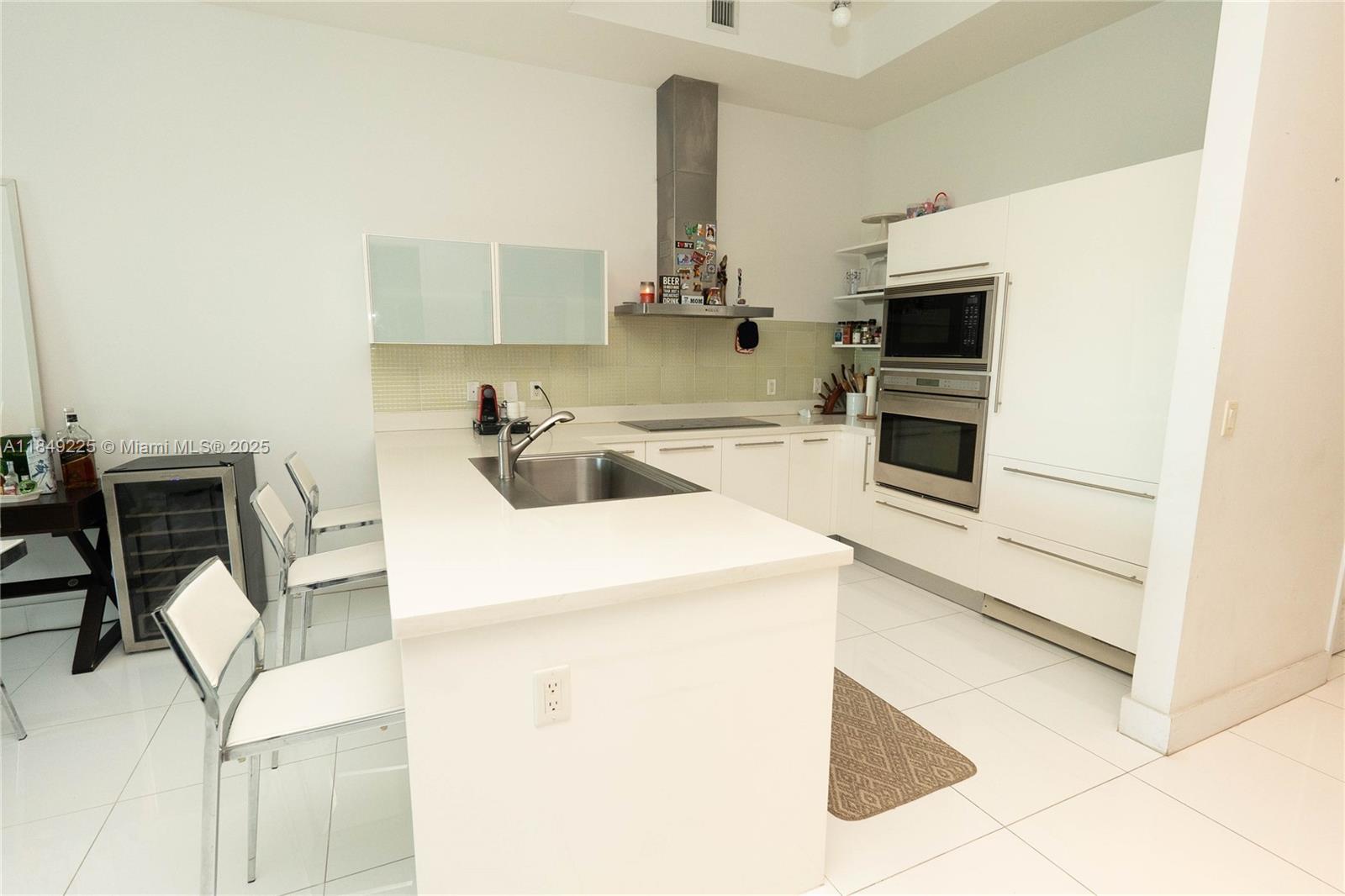 150 Sunny Isles Boulevard, Unit 1TH403 Sunny Isles Beach, FL 33160 - Photo 12 of 34 a kitchen with a sink appliances and cabinets