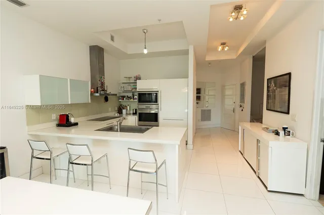 a kitchen with stainless steel appliances kitchen island granite countertop a sink and cabinets
