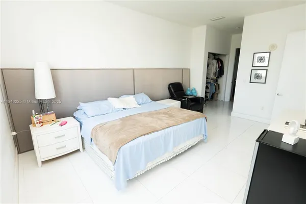 a bedroom with a bed and a potted plant