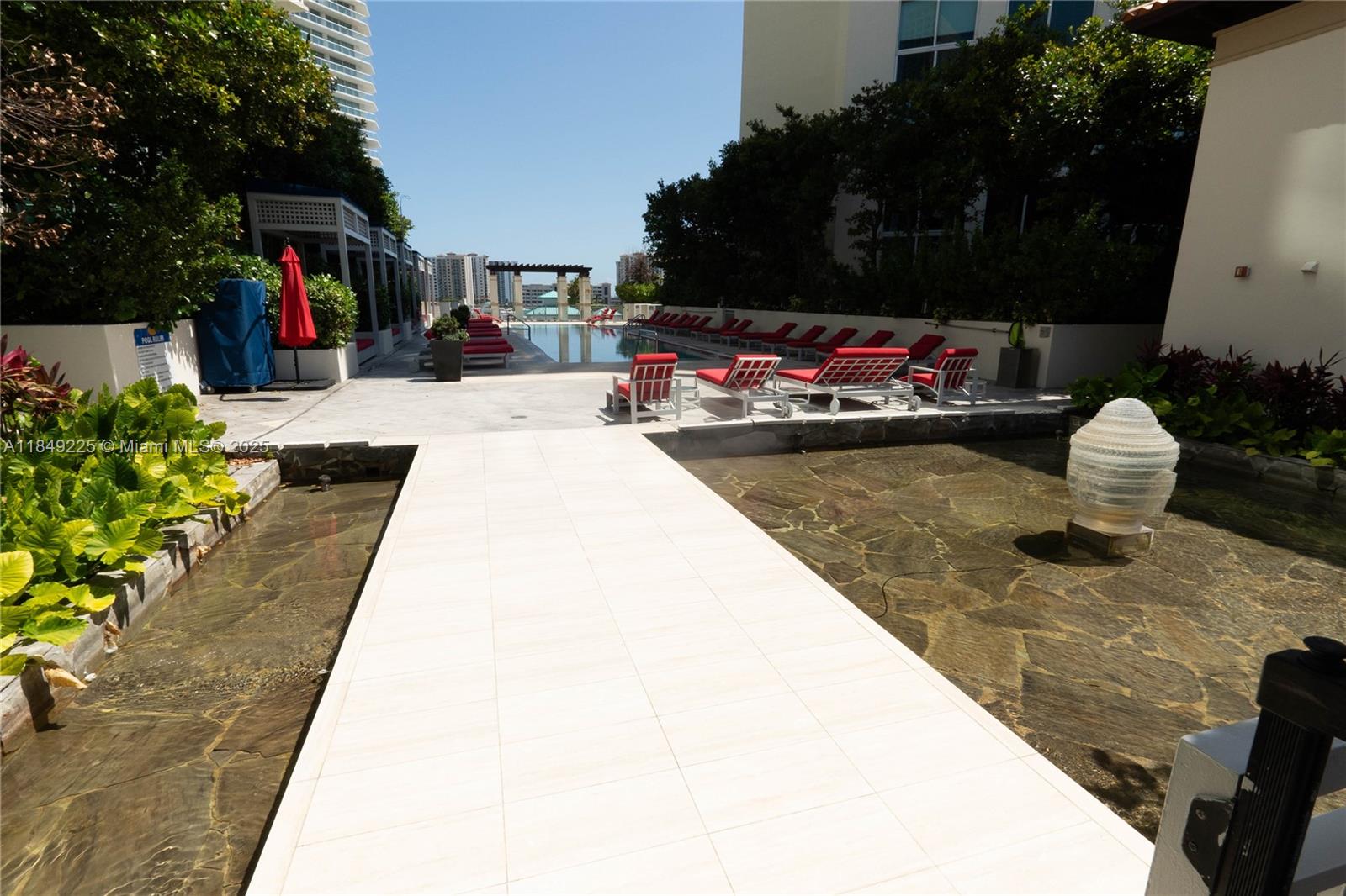 150 Sunny Isles Boulevard, Unit 1TH403 Sunny Isles Beach, FL 33160 - Photo 28 of 34 a view of the patio with dining table and chairs potted plants