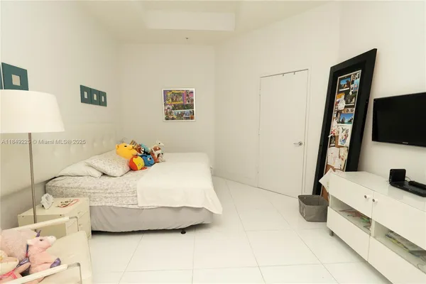 a bedroom with a bed and flat screen tv