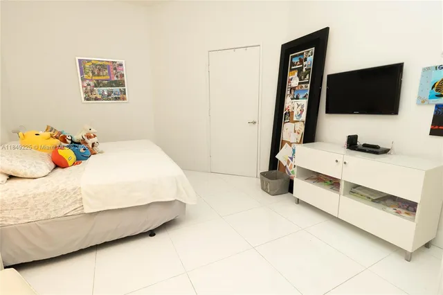 a bedroom with a bed and flat screen tv