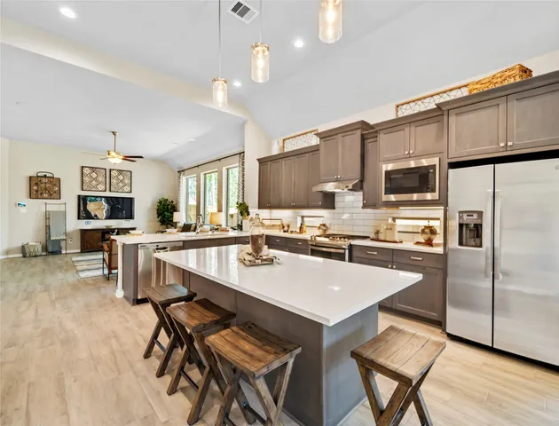 a kitchen with a sink a counter space appliances and cabinets