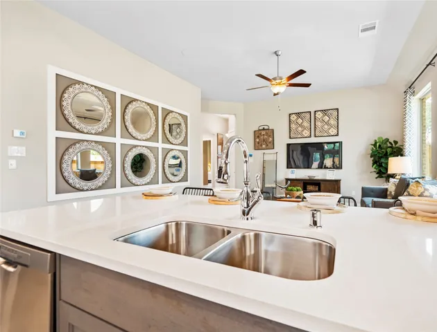 a kitchen with a sink and a stove with wooden floor