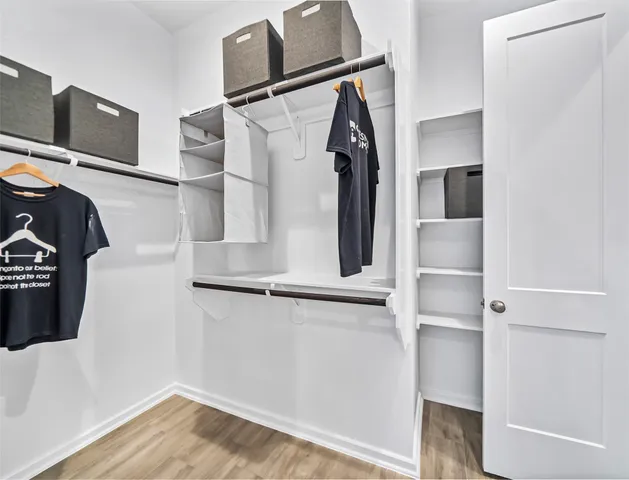 a view of walk in closet with clothes and shoes
