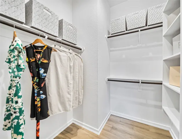 a view of walk in closet with clothes and shoes