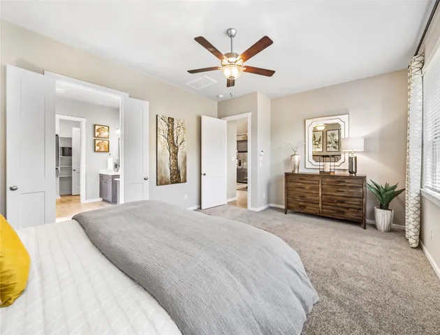 a spacious bedroom with a bed and ceiling fan