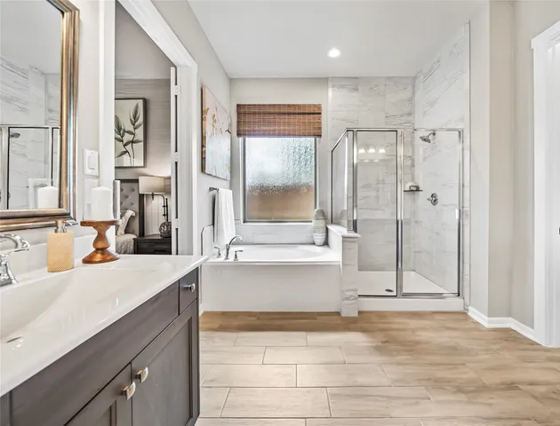 a bathroom with a bathtub shower sink and mirror