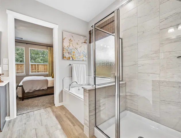 a bathroom with a tub shower and windows
