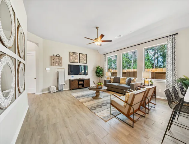 a living room with furniture a fireplace and a large window