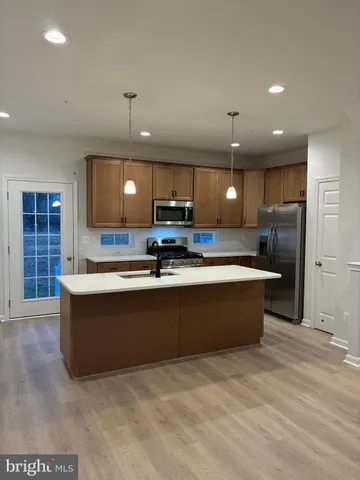 a large kitchen with kitchen island a sink stainless steel appliances and cabinets