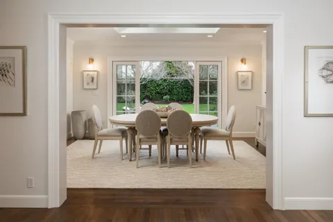 a view of a dining room with furniture a chandelier and wooden floor