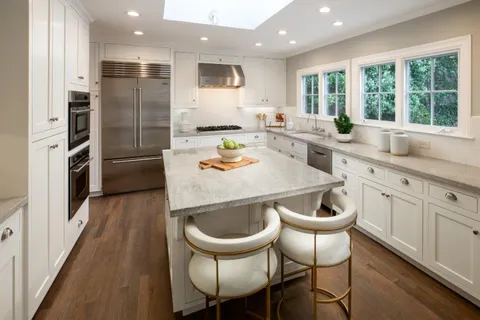 a kitchen with a dining table chairs and refrigerator