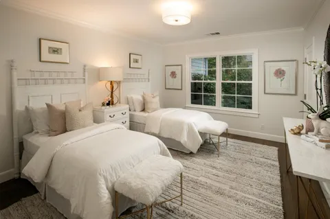 a spacious bedroom with two beds and a large window