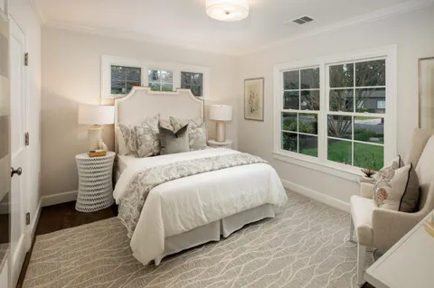 a bedroom with a bed and a large window