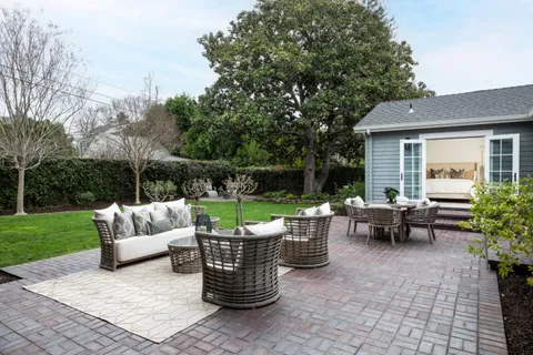a view of a patio with couches and a table and chairs with garden view