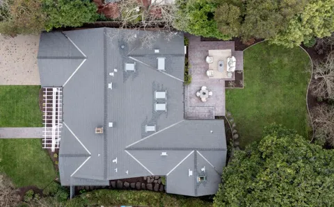 an aerial view of a house with yard and ocean view