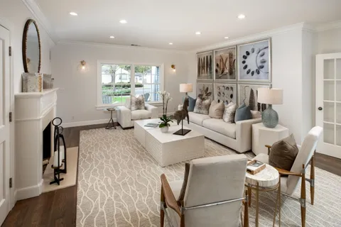 a living room with fireplace furniture and a large window