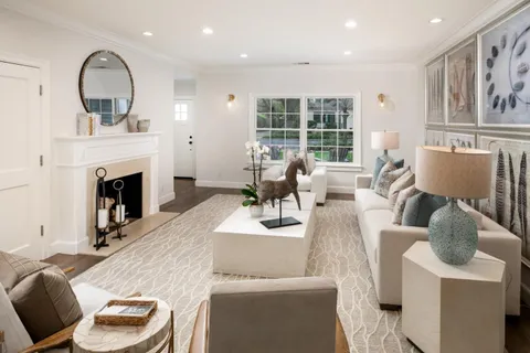 a living room with furniture a fireplace and a large window