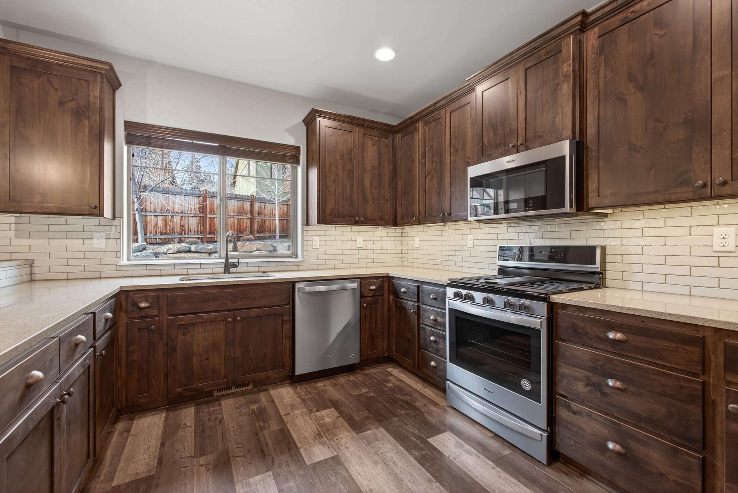 2793 Southwest 33rd Street Redmond, OR 97756 - Photo 11 of 44 a kitchen with stainless steel appliances granite countertop wooden cabinets stove top oven and sink