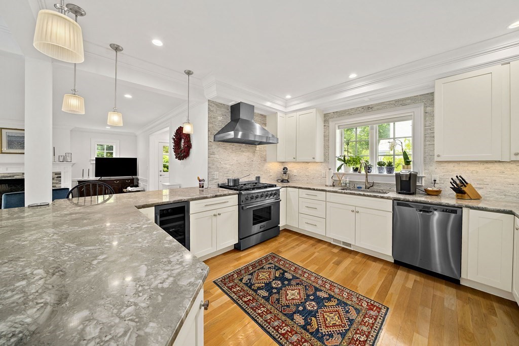 a kitchen with stainless steel appliances kitchen island granite countertop a stove a sink and a refrigerator