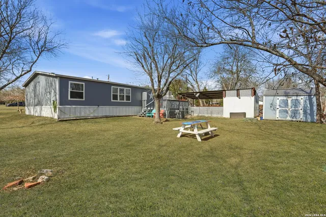 a backyard of a house with table and chairs
