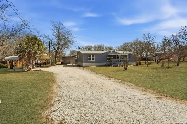 a view of a white house with a yard