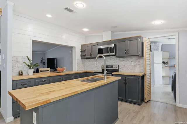 a kitchen with kitchen island granite countertop a sink stove and refrigerator