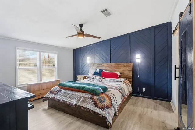 a bedroom with a large bed and a chandelier