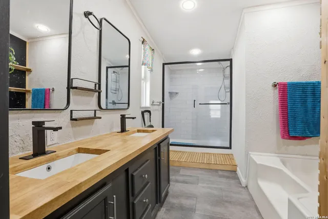 a bathroom with a tub sink and mirror