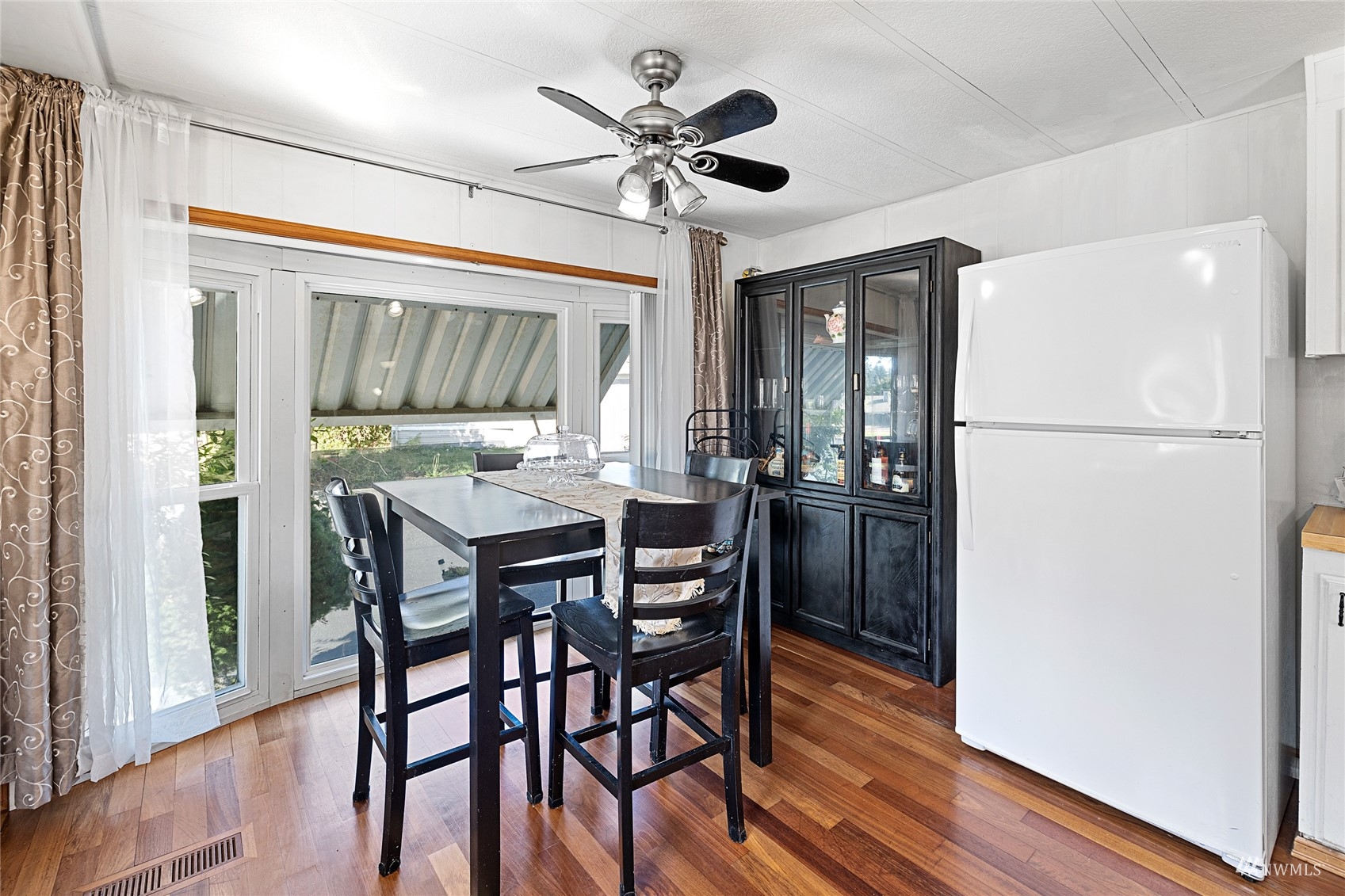 7311 Chambers Creek Road West, Unit 20 University Place, WA 98467 - Photo 13 of 23 a kitchen with stainless steel appliances granite countertop a refrigerator a microwave a stove and a dining table with wooden floor