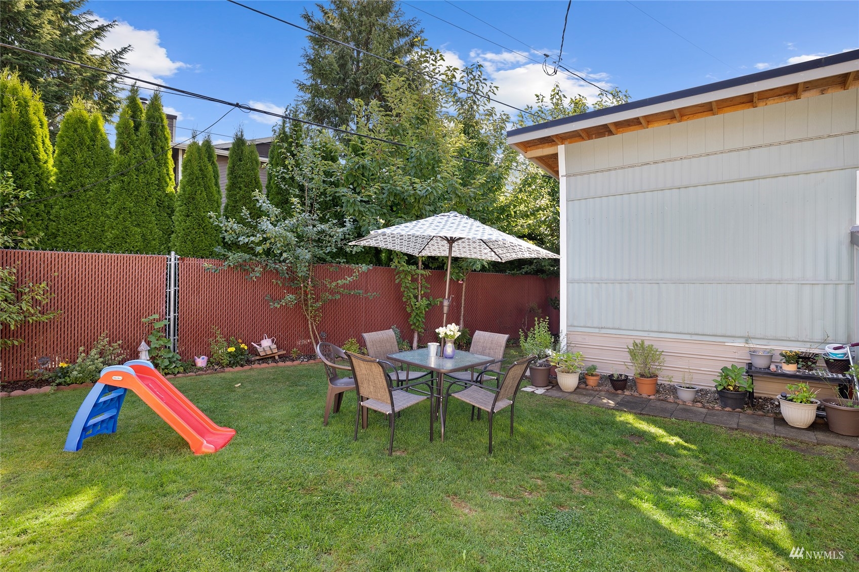 7311 Chambers Creek Road West, Unit 20 University Place, WA 98467 - Photo 8 of 23 a view of a backyard with table and chairs under an umbrella