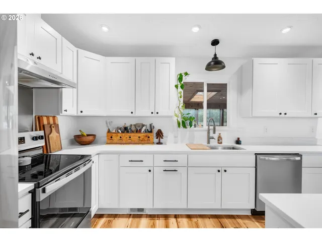a kitchen with kitchen island granite countertop a sink cabinets and stainless steel appliances