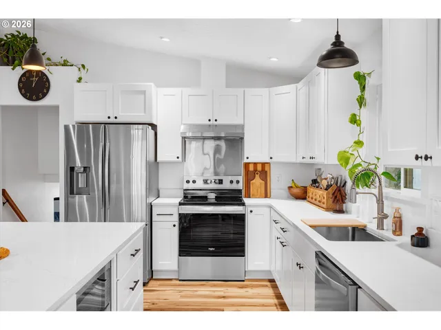 a kitchen with a sink a refrigerator and cabinets