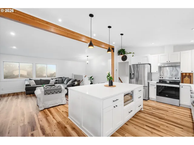 a large white kitchen with stainless steel appliances