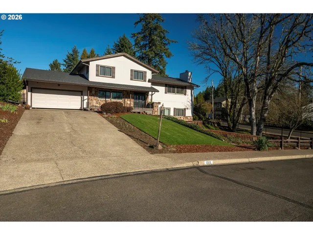 a white house with a large tree with yard