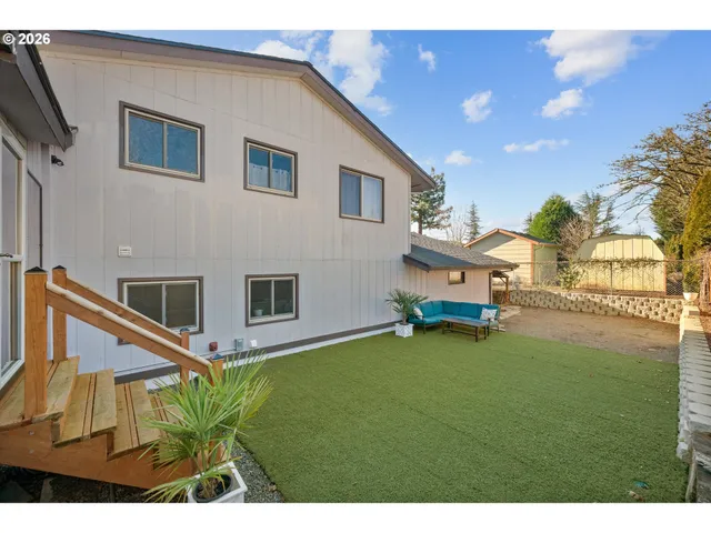 a backyard of a house with table and chairs