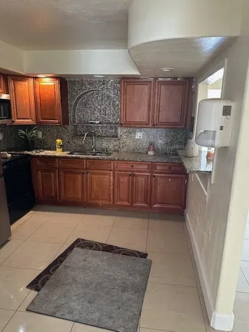 a kitchen with stainless steel appliances granite countertop a sink stove and cabinets