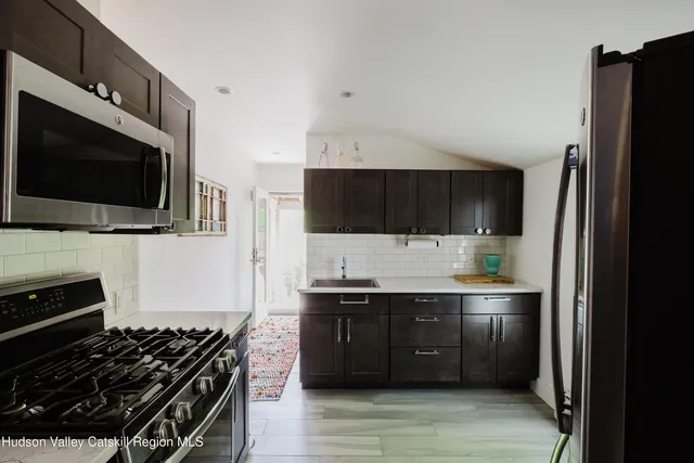 a kitchen with stainless steel appliances granite countertop a refrigerator and a stove top oven