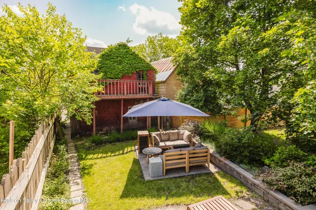 a view of a patio with chairs and a yard with wooden fence