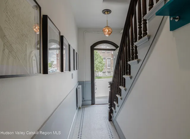 a view of staircase and utility room with windows