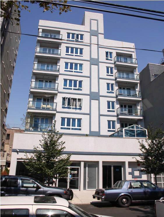 a front view of a building with parking space and windows