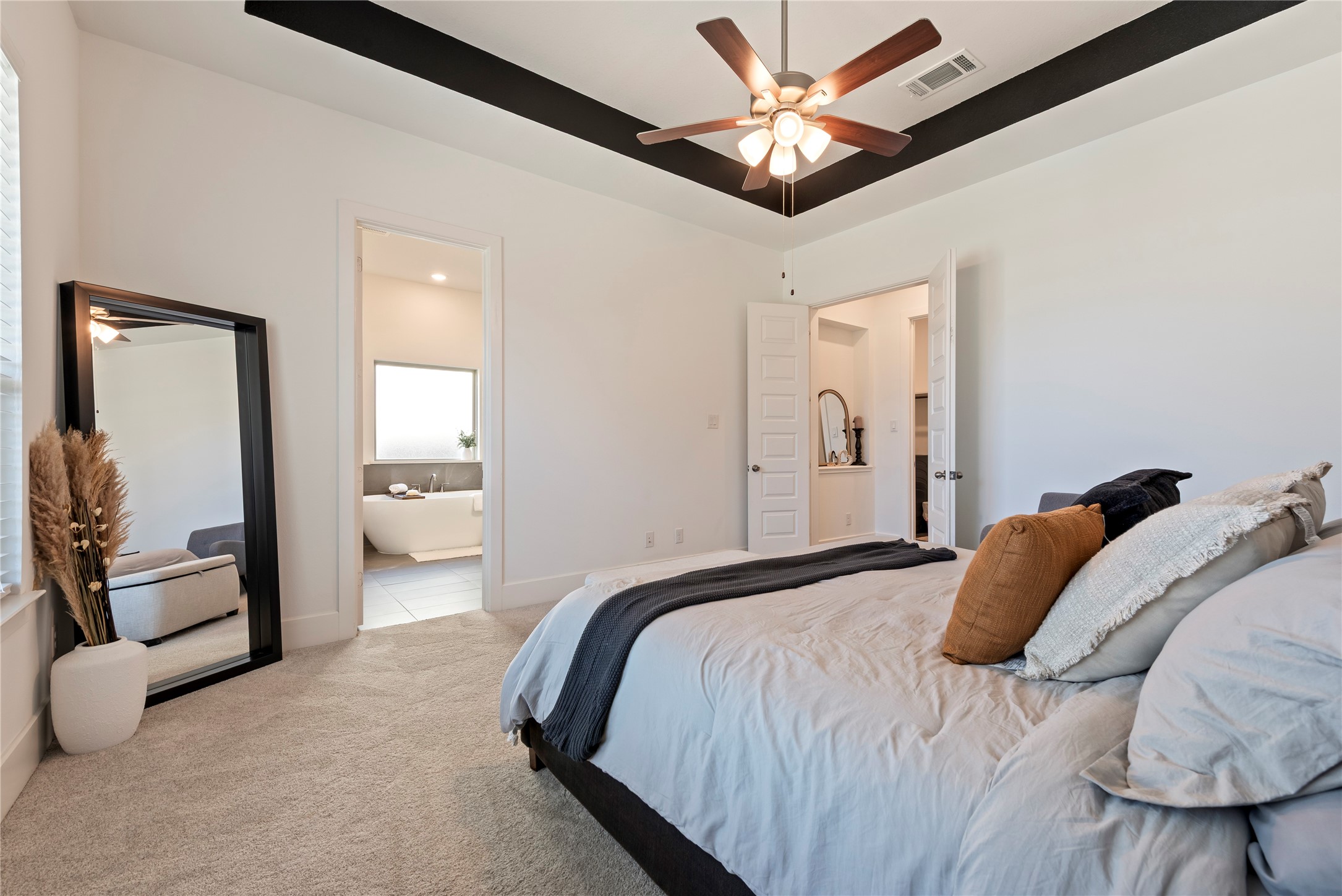 6034 Lake Bridge Lane Manvel, TX 77578 - Photo 12 of 33 a bedroom with a large bed and a chandelier