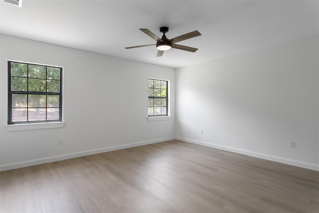 1346 South Reno Road Springtown, TX 76082 - Photo 10 of 24 Spacious room featuring wood-finish flooring, white walls, and a modern ceiling fan with integrated lighting
