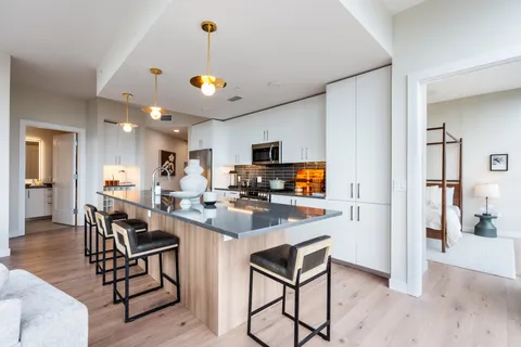 a view of a dining room and livingroom with furniture wooden floor a chandelier
