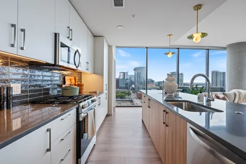 a kitchen with stainless steel appliances a sink a stove and a wooden floors