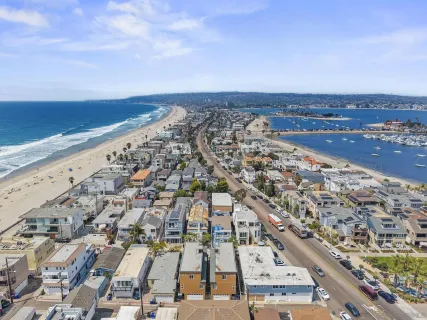 an aerial view of a residential apartment building with a yard and parking spaces