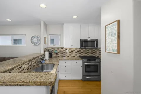a kitchen with sink stove and cabinets