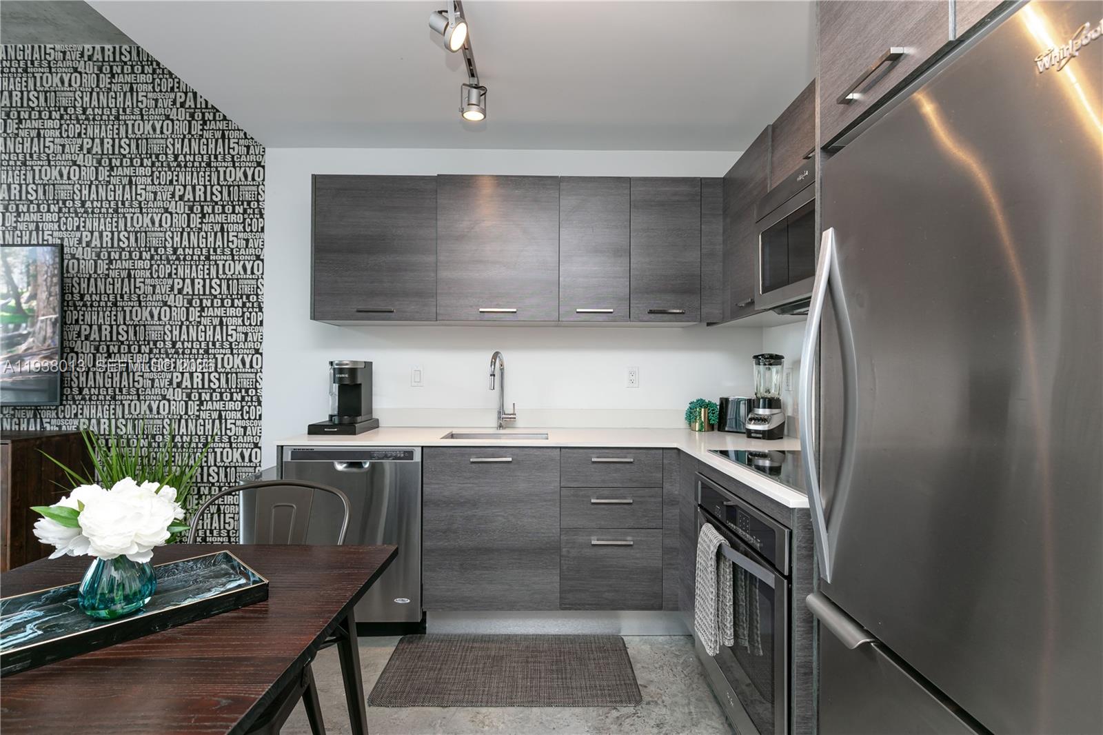 151 Southeast 1st Street, Unit 3103 Miami, FL 33131 - Photo 15 of 51 a kitchen with granite countertop a sink stove and cabinets